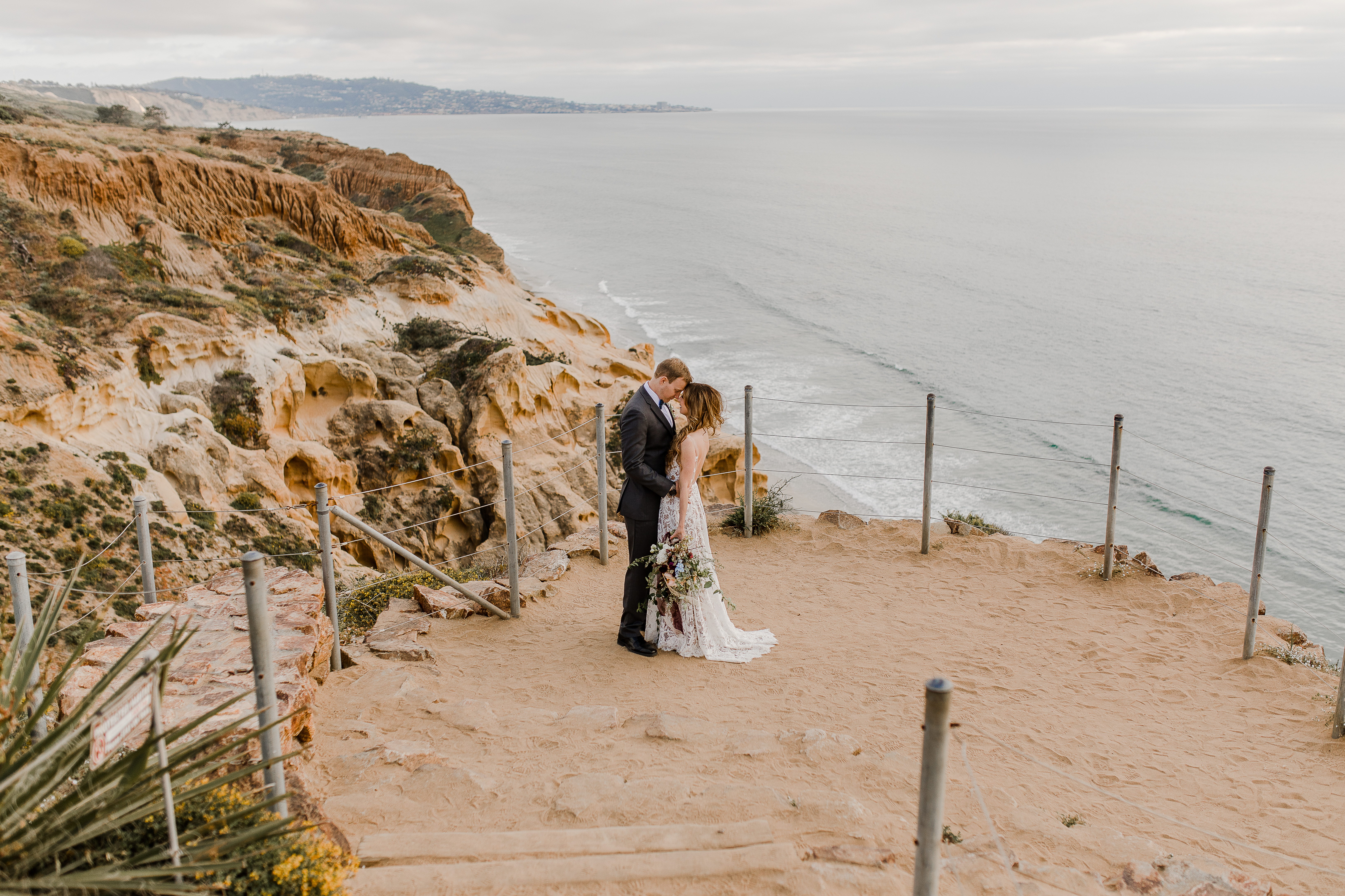 How To Elope in Torrey Pines - couple doing their first kiss on a gorgeous cliff in San Diego, California